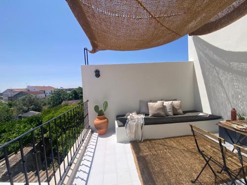 a patio with a couch on a balcony at Casa Amanhada Apartamento Um in Grândola