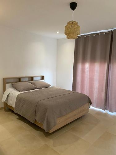 - une chambre avec un lit et une lampe pendant dans l'établissement Studio pour vacances, à Monteux