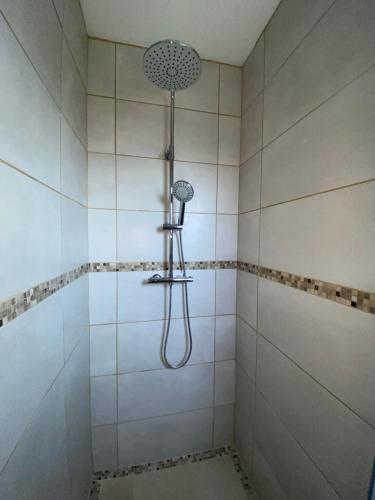 une douche avec pommeau de douche dans une salle de bain dans l'établissement Studio pour vacances, à Monteux