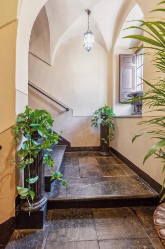 a hallway with potted plants in a building at Palazzo Di Lorenzo - Exclusive Palace with Panoramic Terrace and Minipool in Noto