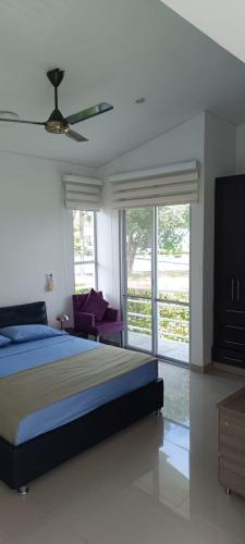 a bedroom with a bed and a ceiling fan at Hermosa Casa Campestre en Ricaurte Girardot in Ricaurte