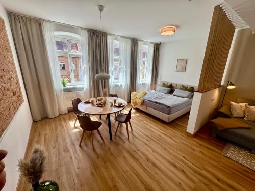 a living room with a table and a couch at Pretti Apartments - Neu, Stilvoll, Zentral, Komfortabel, Geräumig & Ruhig in Bamberg
