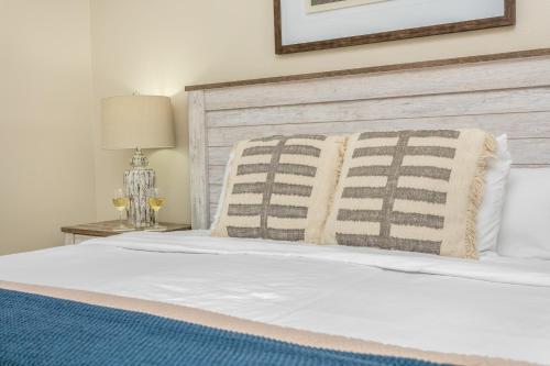 une chambre avec un lit blanc avec une tête de lit en bois dans l'établissement Main Street Retreat #14 - King Bed, On Main St, Shared Hot Tub & Pool, à Fredericksburg