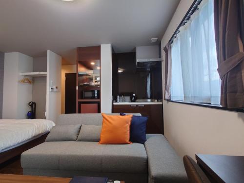 a living room with a couch with an orange pillow at SA Inn Ina Nice Road - Vacation STAY 31748v in Ina