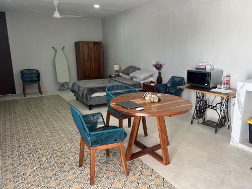 Una sala de estar con una mesa y sillas y una cama. en Loft en Centro de Merida, en Mérida