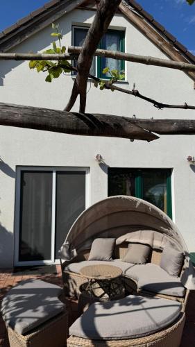 a patio with a chair and a bed in front of a house at Comfort Garden in Dunajská Streda