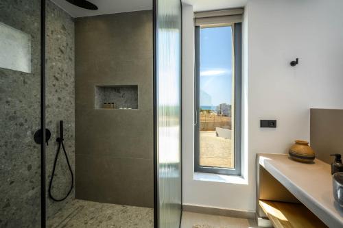 a bathroom with a shower with a glass door at Theros Hani Sea in Kokkíni Khánion