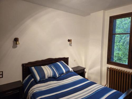 une chambre avec un lit à rayures bleues et blanches dans l'établissement Appartement à la montagne, à Saint Firmin