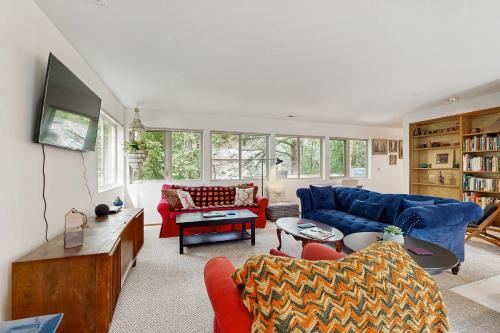 - un salon avec un canapé bleu et des fauteuils rouges dans l'établissement Captain's Quarters Hideaway, à Manzanita