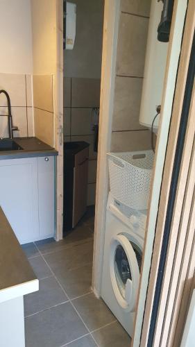 - un lave-linge et un sèche-linge dans une petite cuisine dans l'établissement l'antre de Merlin, à Tréhorenteuc