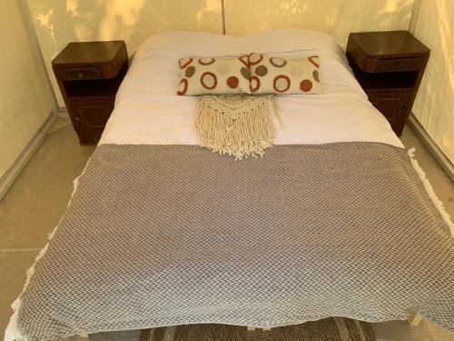 un letto con due comodini e due cuscini sopra di Teffeha tent for 2 