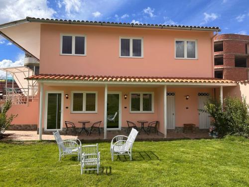 a pink house with chairs and tables in the yard at Villarcadia in Cusco