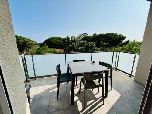 une table et des chaises sur un balcon avec vue dans l'établissement Haut Standing ACCÈS DIRECT MER 3min à pieds,Parking privée, Wifi, Netflix, à Vias