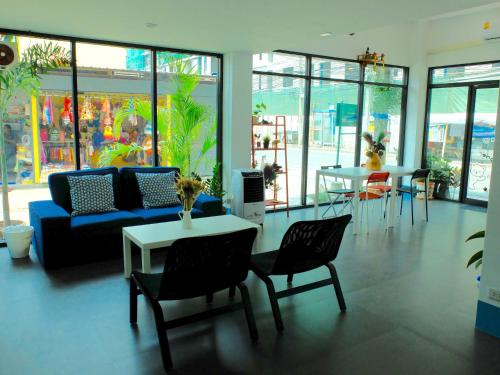 a living room with a couch and a table and chairs at We Inn in Bangkok