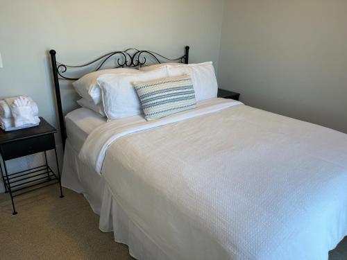 a bedroom with a bed with white sheets and pillows at La Casa Lakeside Resort - Amazing Panoramic View Lakeside House with Pools, Hot Tubs & More! in Kelowna