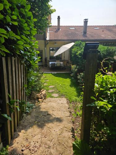 a garden with a fence and an umbrella at Appartement avec jardin dans un château in Lissieu
