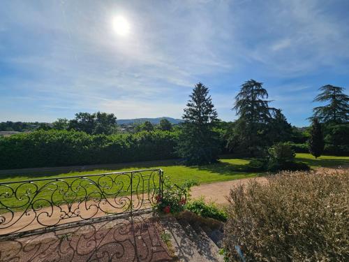 a bench in a park with the sun in the sky at Appartement avec jardin dans un château in Lissieu