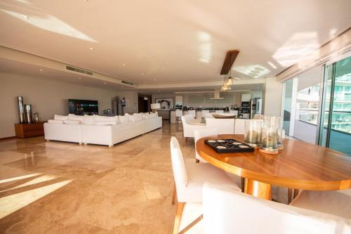 Nuevo NayaritにあるLuxury Penthouse in Nuevo Vallartaのテーブルと白い椅子のあるダイニングルーム