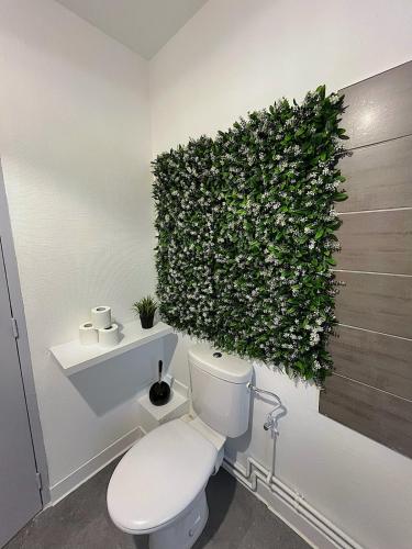 La salle de bains est pourvue de toilettes et d'une plante murale. dans l'établissement F3 Wabi-Sabi, à Strasbourg