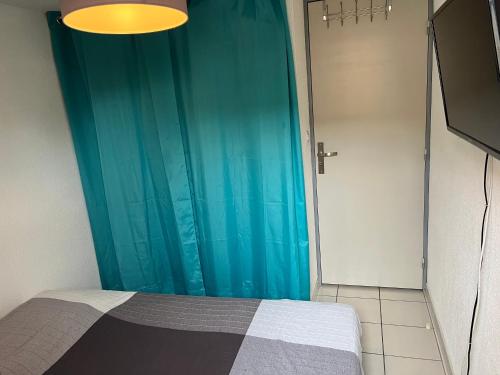 - une chambre avec un lit doté d'un rideau de douche bleu dans l'établissement Maison 3ch 250m mer - piscine - Clim, à Sainte-Marie-la-Mer