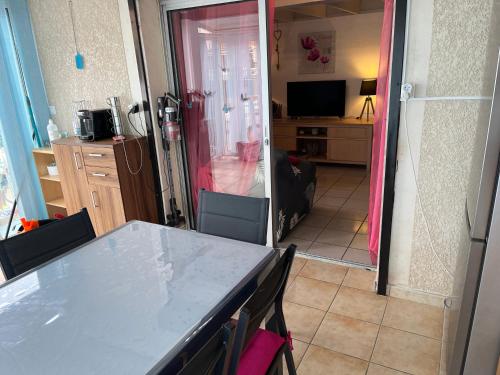 une cuisine avec une table et des chaises dans une pièce dans l'établissement Maison 3ch 250m mer - piscine - Clim, à Sainte-Marie-la-Mer