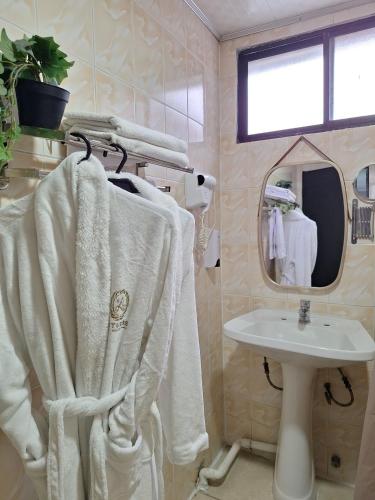 a bathroom with a sink and a white towel at Hotel Asturias in Viña del Mar