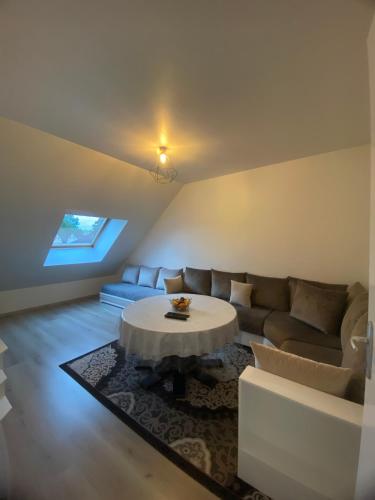 un salon avec un canapé et une table dans l'établissement Appartement proche de l'entrée des 24h, au Mans