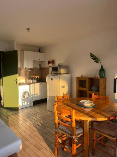Il comprend une cuisine et une salle à manger avec une table et un réfrigérateur. dans l'établissement Studio cabine - Grau du Roi, au Grau-du-Roi