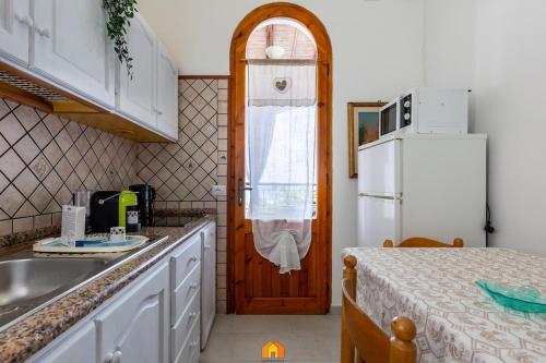 une cuisine avec un évier et un réfrigérateur dans l'établissement Holiday House la terrazza, à Costa Rei