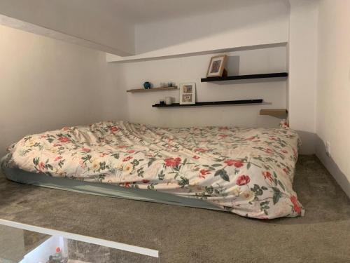 - un lit avec une couette à fleurs dans une chambre dans l'établissement Studette Cosy, à Nice
