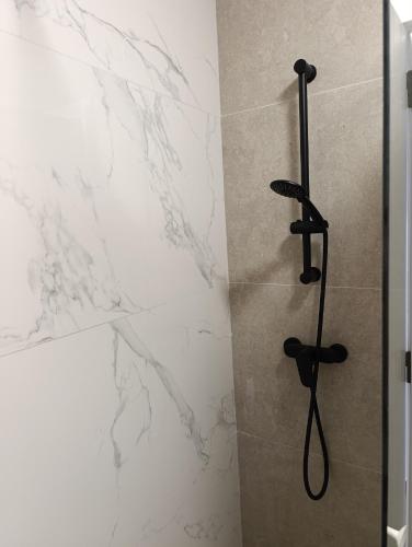 a bathroom with a shower with a black shower head at Apartamento Ideal in Alaior
