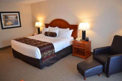 a hotel room with a bed and a chair at Inn on Long Lake in Nanaimo