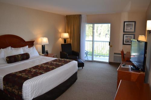 a hotel room with a bed and a television at Inn on Long Lake in Nanaimo