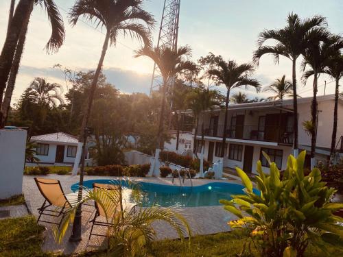 a resort with a swimming pool and palm trees at Villas manuel antonio in Quepos