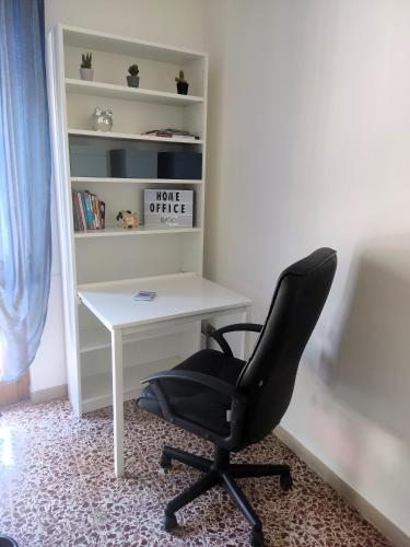 a black chair sitting next to a white desk at Casa Rubio in Camaiore