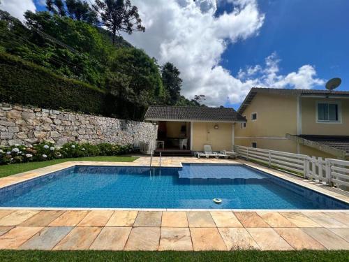 a swimming pool in front of a house at Recanto da montanha in Teresópolis