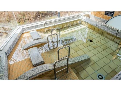a swimming pool with stairs and benches on a building at Ouka no sato La-Foret Shobara - Vacation STAY 35116v in Shōbara