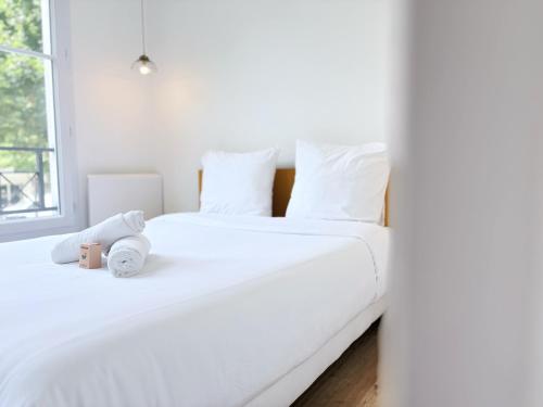 2 weiße Betten in einem Zimmer mit Fenster in der Unterkunft Le Genêt Disney 15min Train 8min Paris Parking in Bussy-Saint-Georges