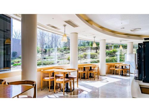 a restaurant with tables and chairs and large windows at Ouka no sato La-Foret Shobara - Vacation STAY 35116v in Shōbara