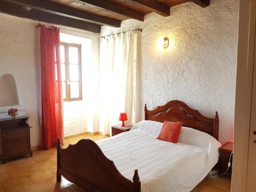 une chambre avec un lit avec des draps blancs et une fenêtre dans l'établissement A punta di Cupabia, à Serra-di-Ferro