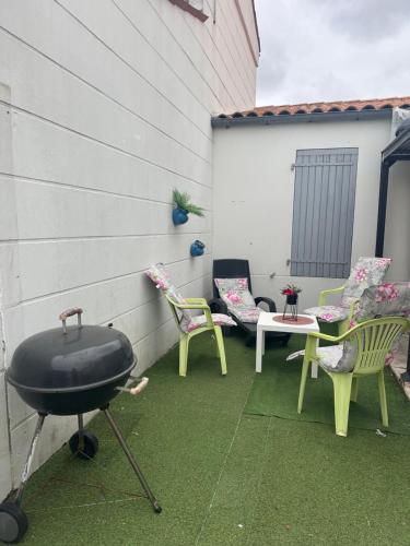 - un barbecue sur une terrasse avec des chaises et une table dans l'établissement La rechelaise, à La Rochelle
