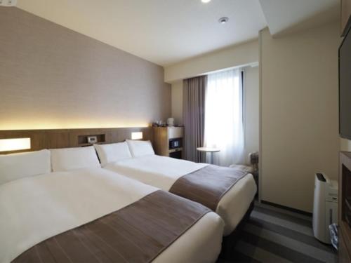 a hotel room with two beds and a television at Far East Village Hotel Yokohama - Vacation STAY 27895v in Yokohama