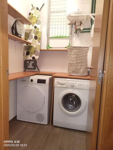 a laundry room with a washing machine and a window at El Pedragal in La Alberca