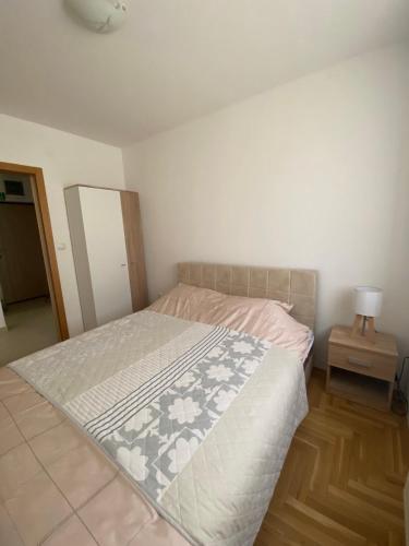 a bedroom with a bed and a lamp on a wooden floor at Lake View EIA in Lukavica