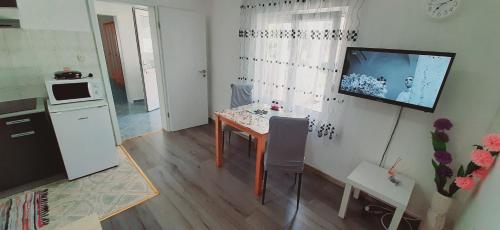 a kitchen with a table and a television on a wall at Ema & Sea Apartment's in Pula