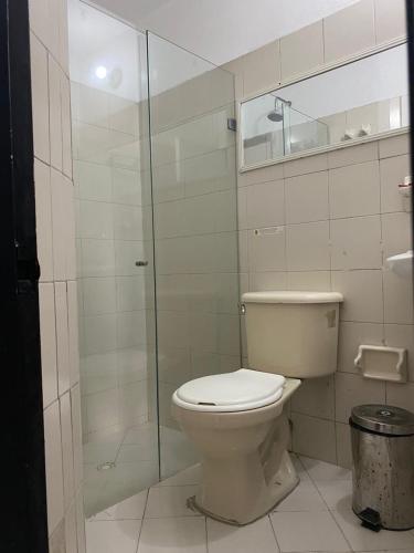 a bathroom with a toilet and a glass shower at Hmetrohotel in Medellín