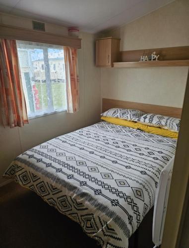 a bed in a small room with a window at Golden Palm - Meadow Lakes in Chapel Saint Leonards