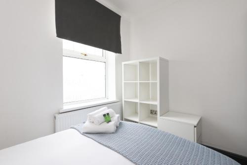 a white bedroom with a bed and a window at Luxury Living, Central Spot in Cardiff