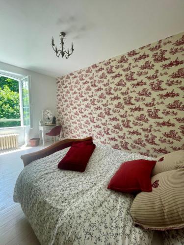 a bedroom with a large bed with red pillows at Manoir Maison Ma Valérie in Castétis