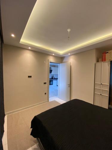 a bedroom with a black bed and a refrigerator at Rubin residence in Alanya